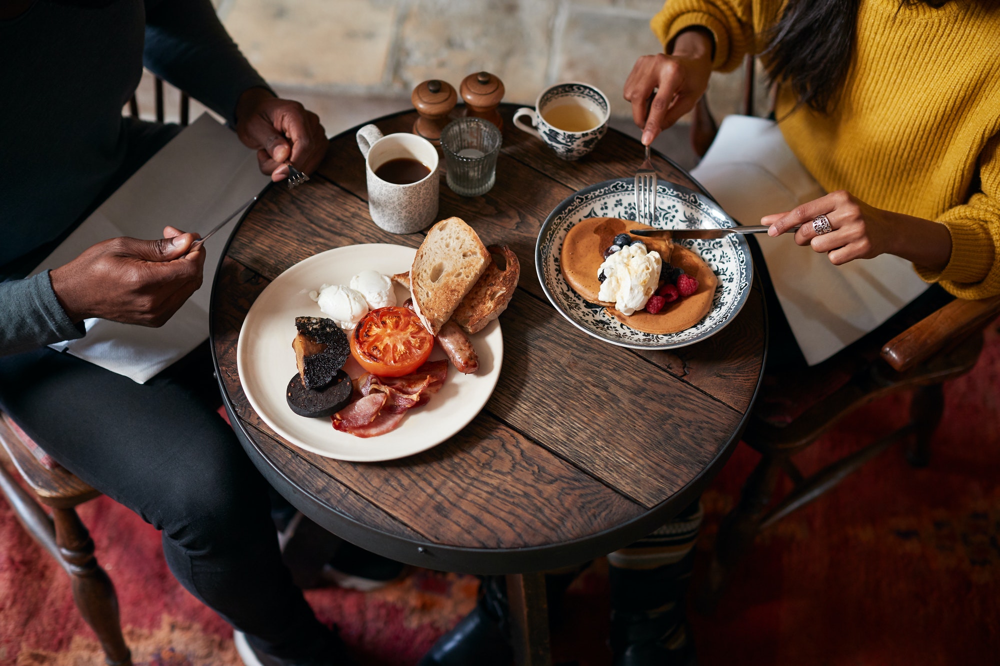 Close Up Of Couple At Table In Traditional English Pub Eating Breakfast