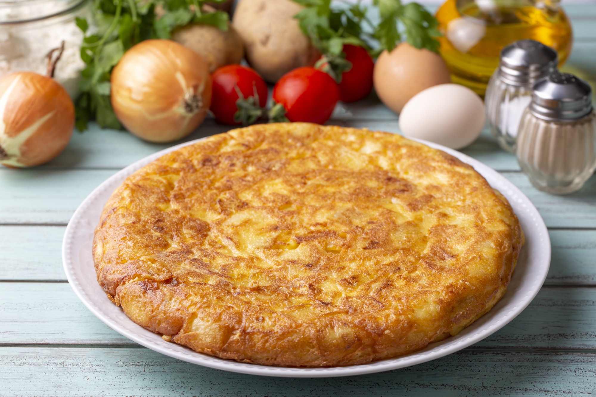 Spanish omelette with potatoes, typical spanish cuisine on gray concrete floor. Tortilla Espanola.